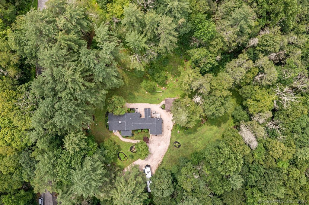 an aerial view of residential house with outdoor space and trees all around