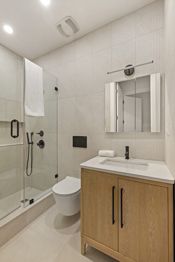 1230 Putnam Avenue, Unit 2 Brooklyn, NY 11221 - Photo 12 of 13 a bathroom with a granite countertop sink a toilet and a mirror