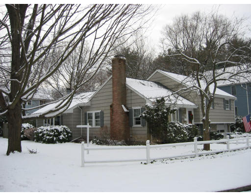 front view of a house with a yard covered in snow