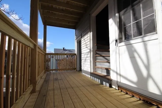 a view of a balcony with wooden floor and fence