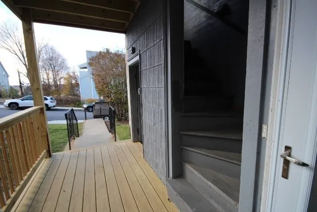 a view of a balcony with chairs and wooden floor