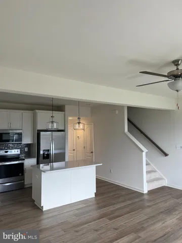 a large kitchen with cabinets wooden floor and stainless steel appliances