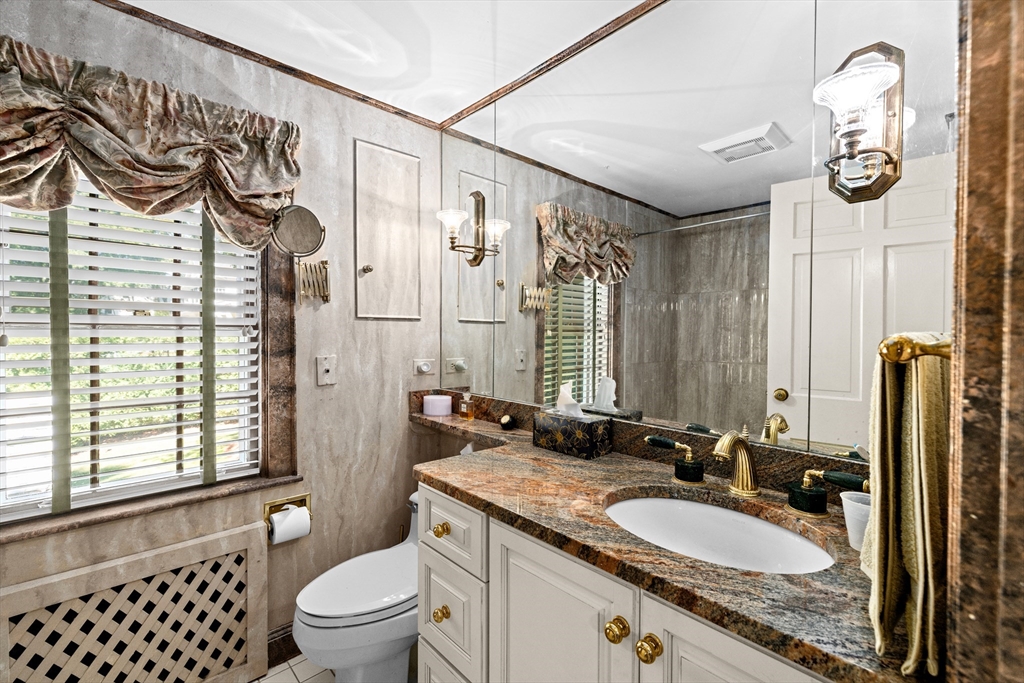 443 Chestnut Street Newton, MA 02468 - Photo 20 of 28 a bathroom with a granite countertop sink a toilet a mirror a window and shower