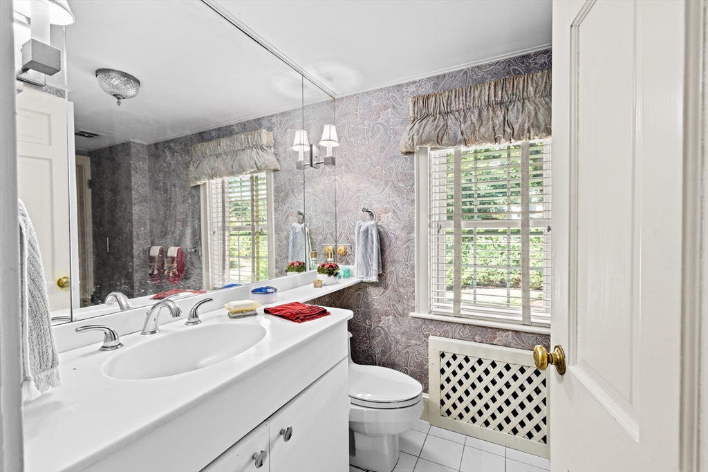 443 Chestnut Street Newton, MA 02468 - Photo 22 of 28 a bathroom with a sink toilet a mirror and a shower
