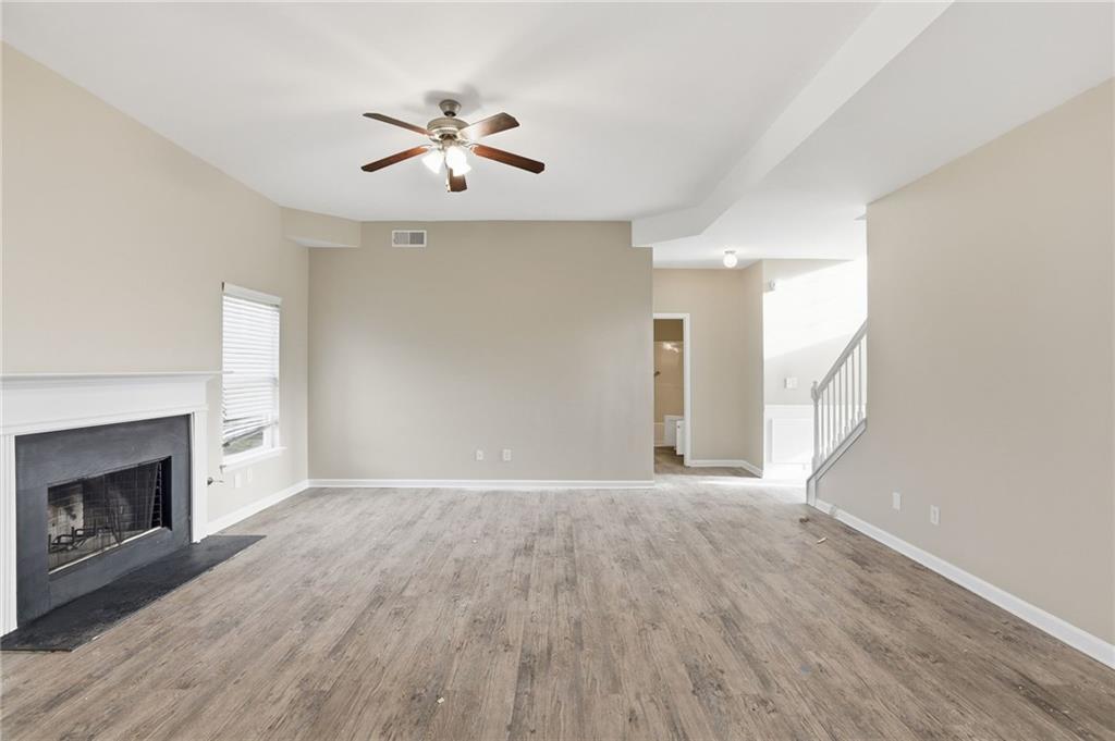 4968 Locherby Drive Fairburn, GA 30213 - Photo 8 of 39 a view of an empty room with wooden floor and a fireplace