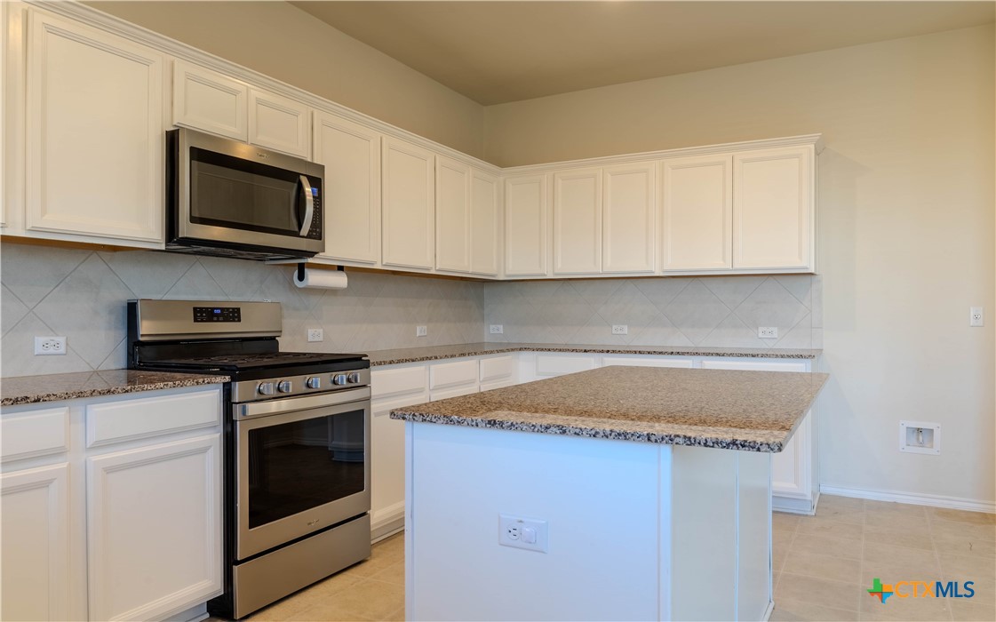 620 English Oak Street Georgetown, TX 78626 - Photo 8 of 29 a kitchen with stainless steel appliances granite countertop a sink a stove a microwave oven and cabinets