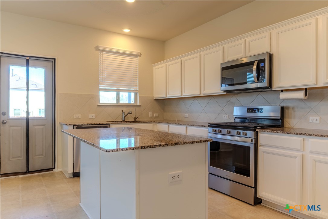 620 English Oak Street Georgetown, TX 78626 - Photo 9 of 29 a kitchen with granite countertop white cabinets and stainless steel appliances