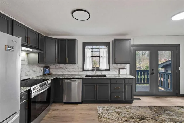 a kitchen with stainless steel appliances granite countertop a sink stove and refrigerator