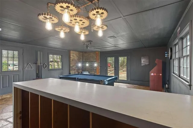 a room with pool table and windows