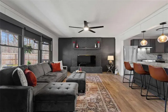 a living room with furniture a fireplace and a large window