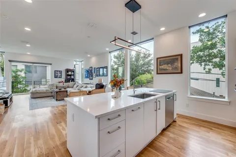 a large kitchen with kitchen island a large counter space appliances and a living room view