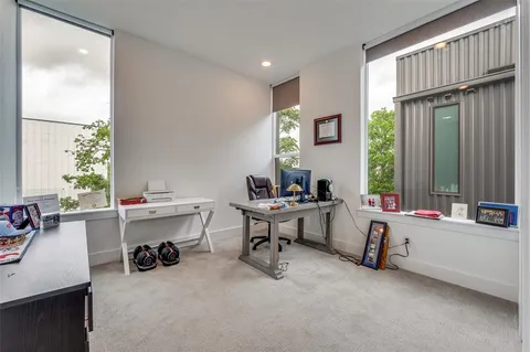 a view of a workspace with furniture and a window