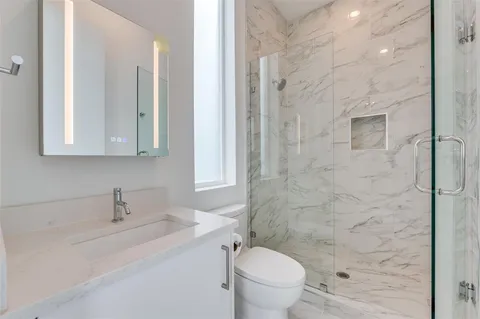 a bathroom with a sink a toilet and shower
