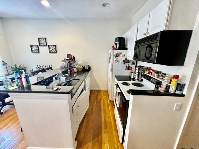 17 Thacher Street, Unit 3 Boston, MA 02113 - Photo 7 of 24 a kitchen with stainless steel appliances a stove top oven a sink a chimney and a refrigerator