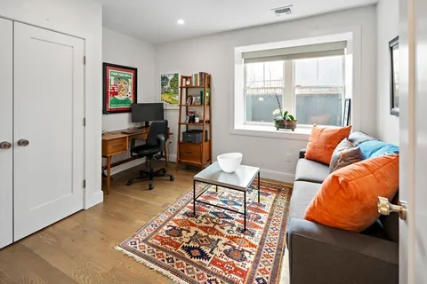 a living room with furniture a rug and a large window