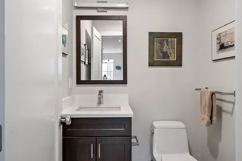 a bathroom with a toilet sink and mirror