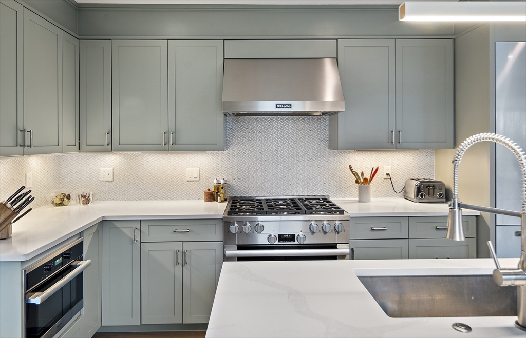 186 Mason Terrace, Unit 186 Brookline, MA 02446 - Photo 6 of 27 a kitchen with stainless steel appliances granite countertop a sink stove and cabinets