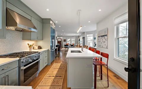 a kitchen with stainless steel appliances kitchen island granite countertop a stove and a sink