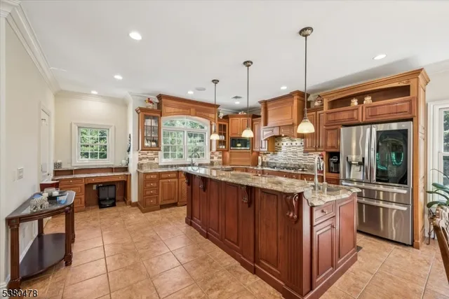 a kitchen with kitchen island granite countertop a sink counter top space appliances and cabinets