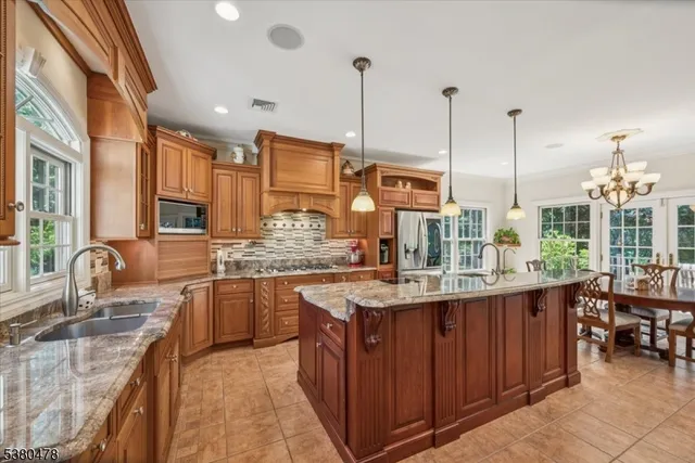 a kitchen with kitchen island granite countertop a sink counter top space appliances and cabinets
