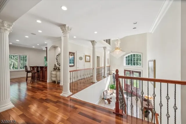 a view of a hallway with wooden floor and windows