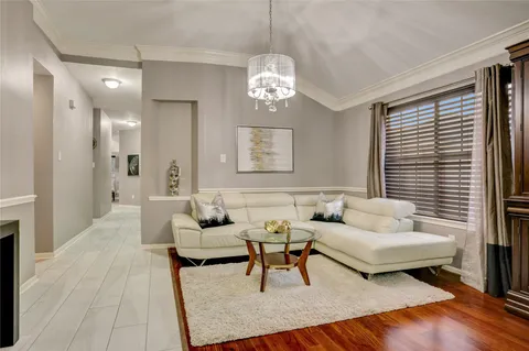 a living room with furniture and a chandelier