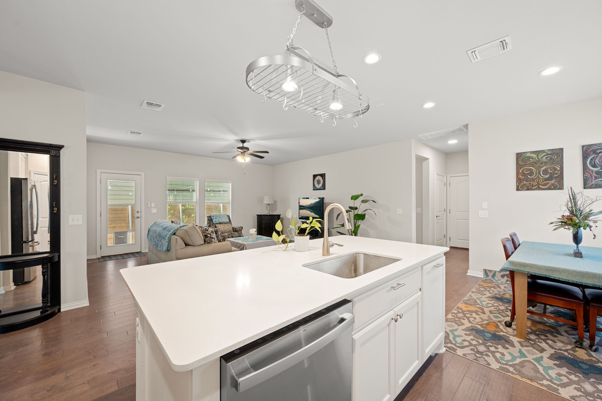 8800 Slater Drive Austin, TX 78747 - Photo 5 of 40 a large white kitchen with a large island oven a stove a sink a dining table and chairs