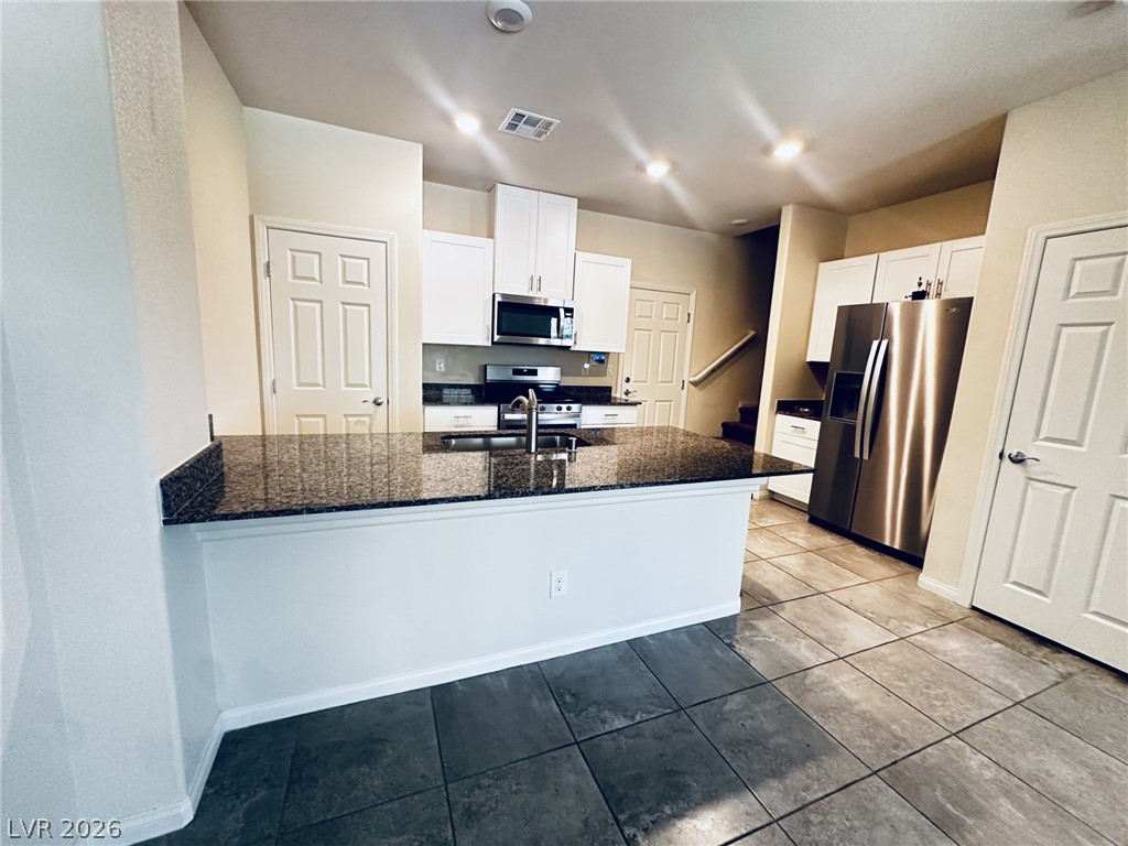 7331 Sunray Point Street North Las Vegas, NV 89084 - Photo 2 of 20 A well-appointed kitchen showcasing dark granite countertops and stainless steel appliances.