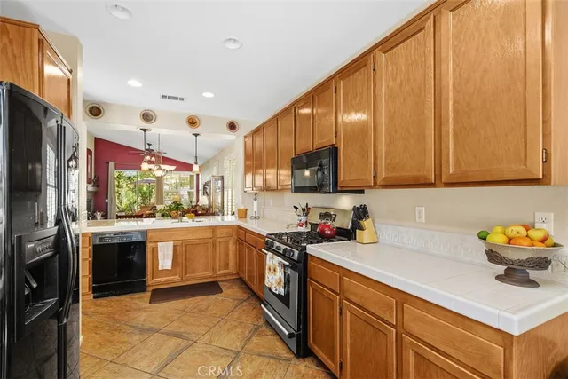 a kitchen with stainless steel appliances granite countertop a sink refrigerator and cabinets