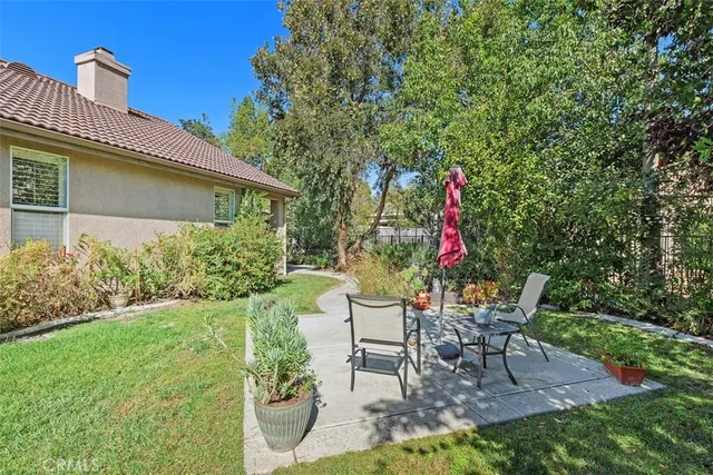a view of a chair and table in backyard of the house