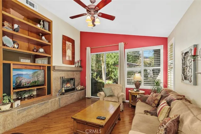 a living room with furniture a floor to ceiling window and a flat screen tv