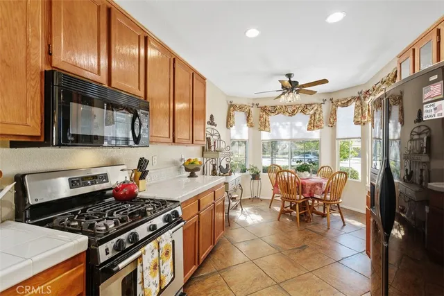 a kitchen with stainless steel appliances stove top oven table and chairs