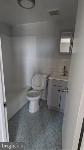 a white toilet sitting next to a bathroom sink