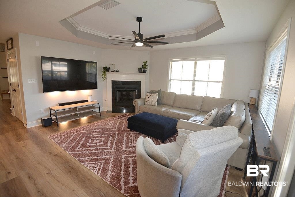 11201 Herschel Loop Daphne, AL 36526 - Photo 4 of 32 Living room featuring ornamental molding, ceiling fan, wood-type flooring, and a raised ceiling