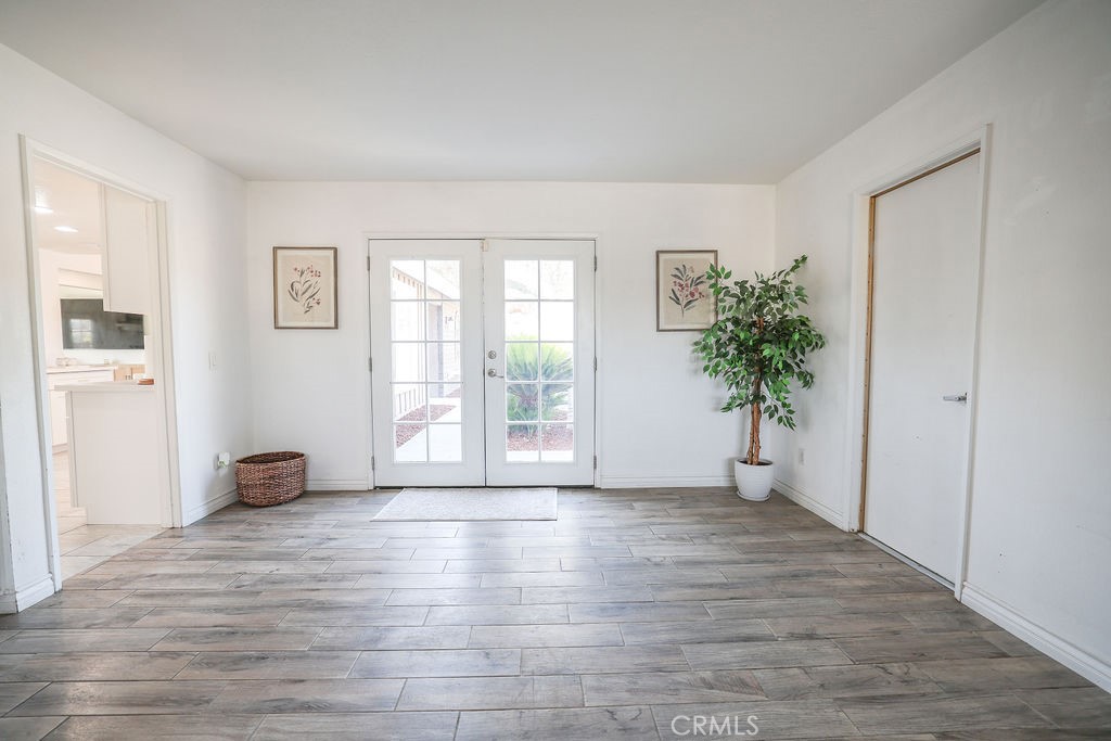 16465 Holcomb Way Riverside, CA 92504 - Photo 15 of 49 Living Room with french doors that lead to pathway in front yard. Door on the right is the garage. Entrance to Kitchen on the left