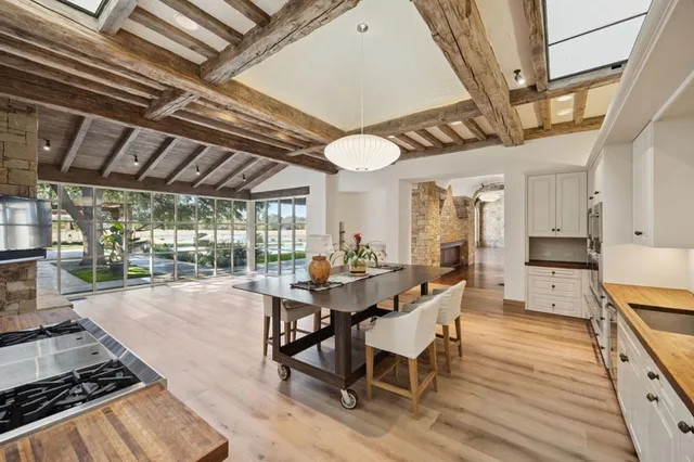 a dining room with wooden floor a chandelier a wooden table and chairs