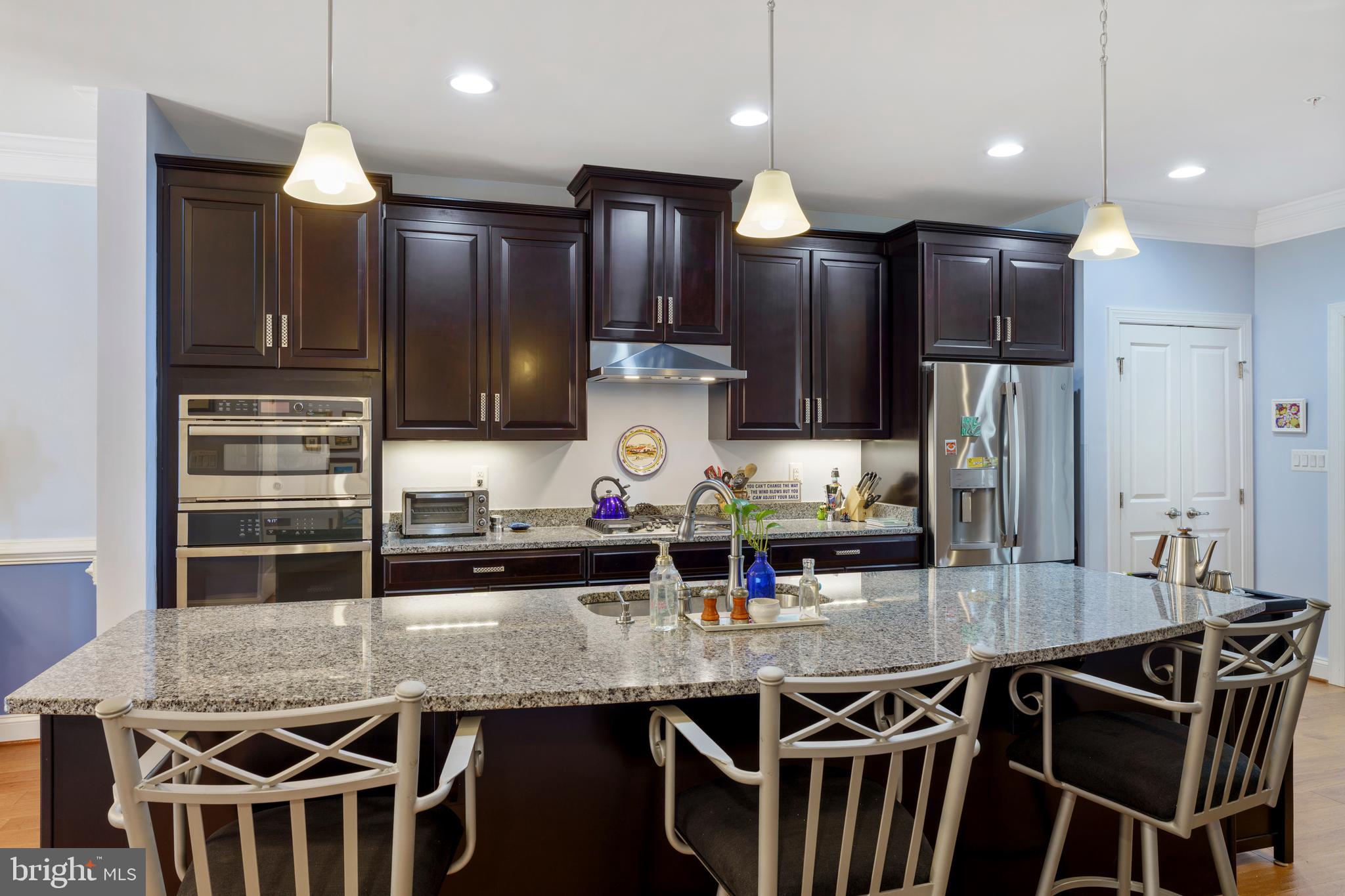 6926 Summit Circle Baltimore, MD 21239 - Photo 13 of 52 a kitchen with stainless steel appliances granite countertop a kitchen island stools a stove a refrigerator and cabinets
