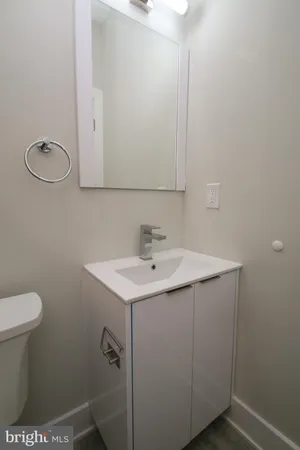 a bathroom with a sink a toilet and a mirror