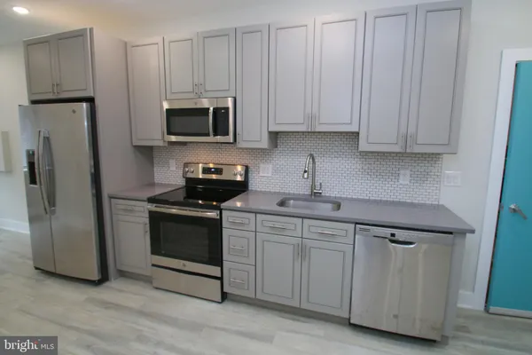 a kitchen with appliances a sink and a refrigerator