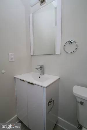 a bathroom with a sink toilet and mirror