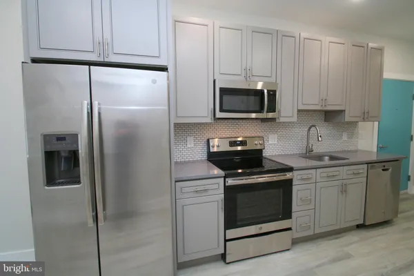 a kitchen with cabinets stainless steel appliances and a counter space