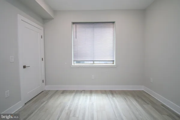 a view of a small space with wooden floor and a window