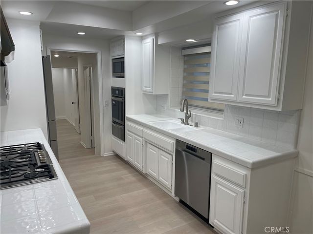 a kitchen with a sink stove and refrigerator