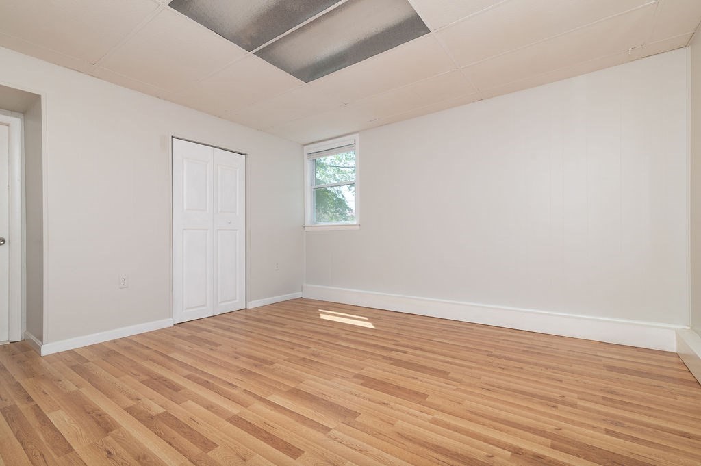 34 Clark Road Rockland, MA 02370 - Photo 11 of 37 a view of an empty room with wooden floor and a window