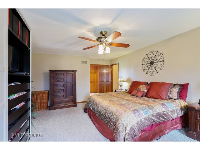 978 Plum Tree Road Fox River Grove, IL 60021 - Photo 16 of 25 a bedroom with a bed and a chandelier