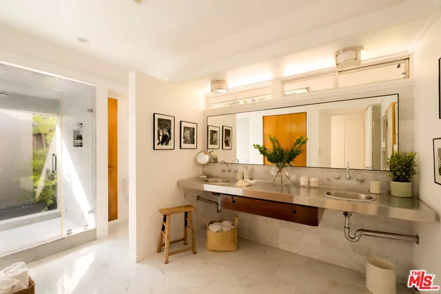 a backyard of a house with table and chairs and potted plants
