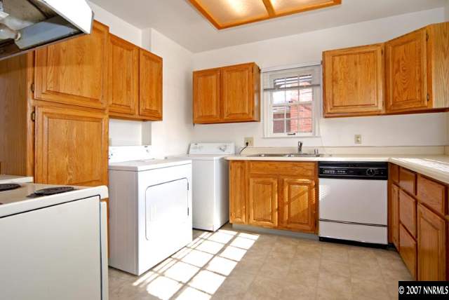 517 Thoma Street Reno, NV 89502 - Photo 3 of 9 a utility room with sink a washer and dryer with wooden cabinets
