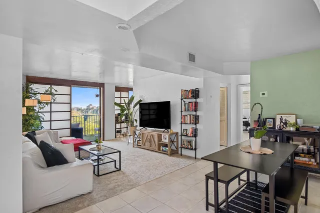 a living room with furniture flat screen tv and a large window