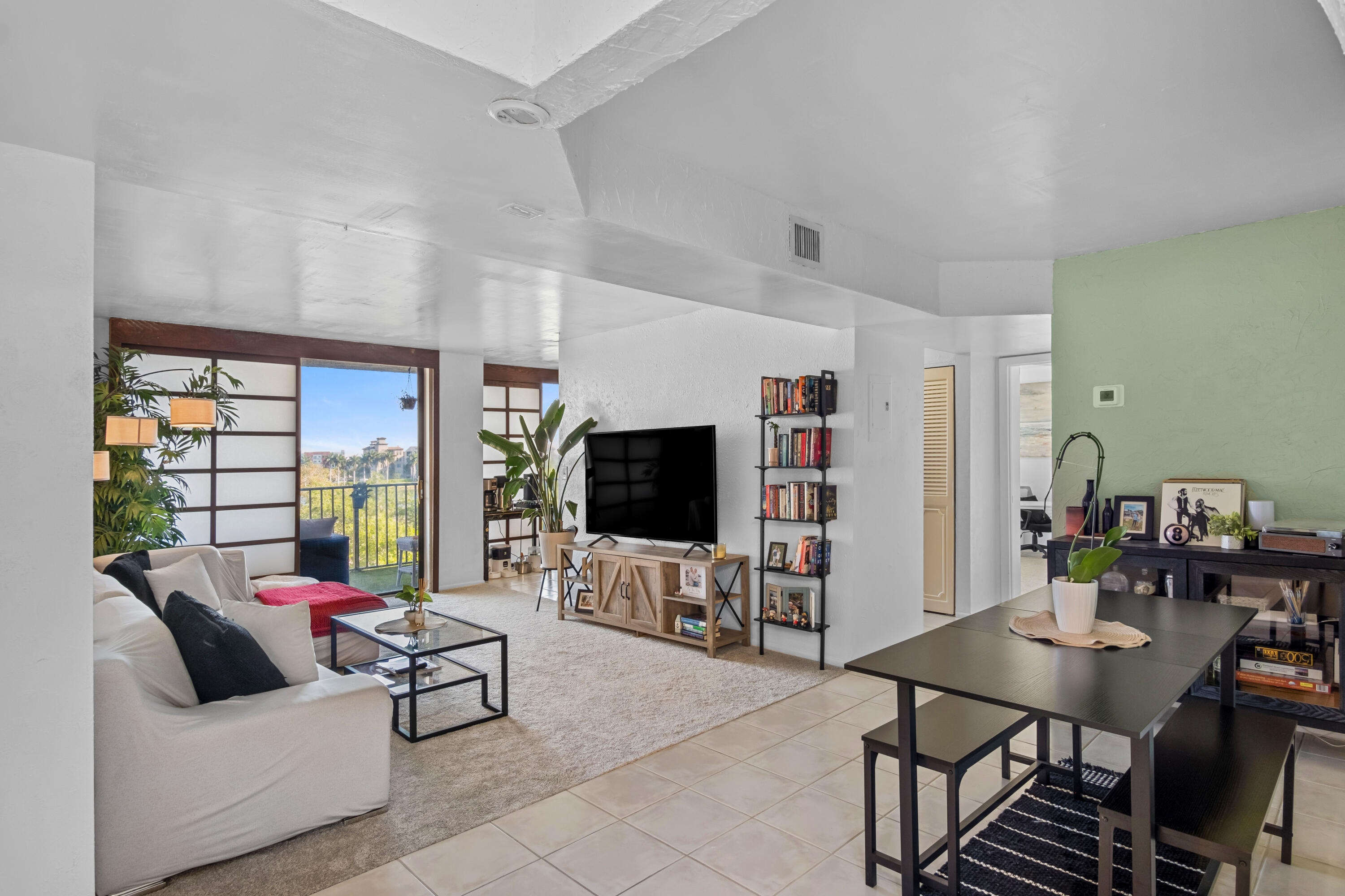 a living room with furniture flat screen tv and a large window