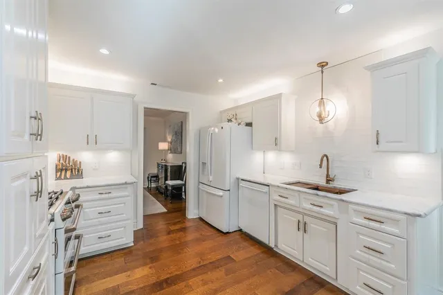 a kitchen with white cabinets and refrigerator